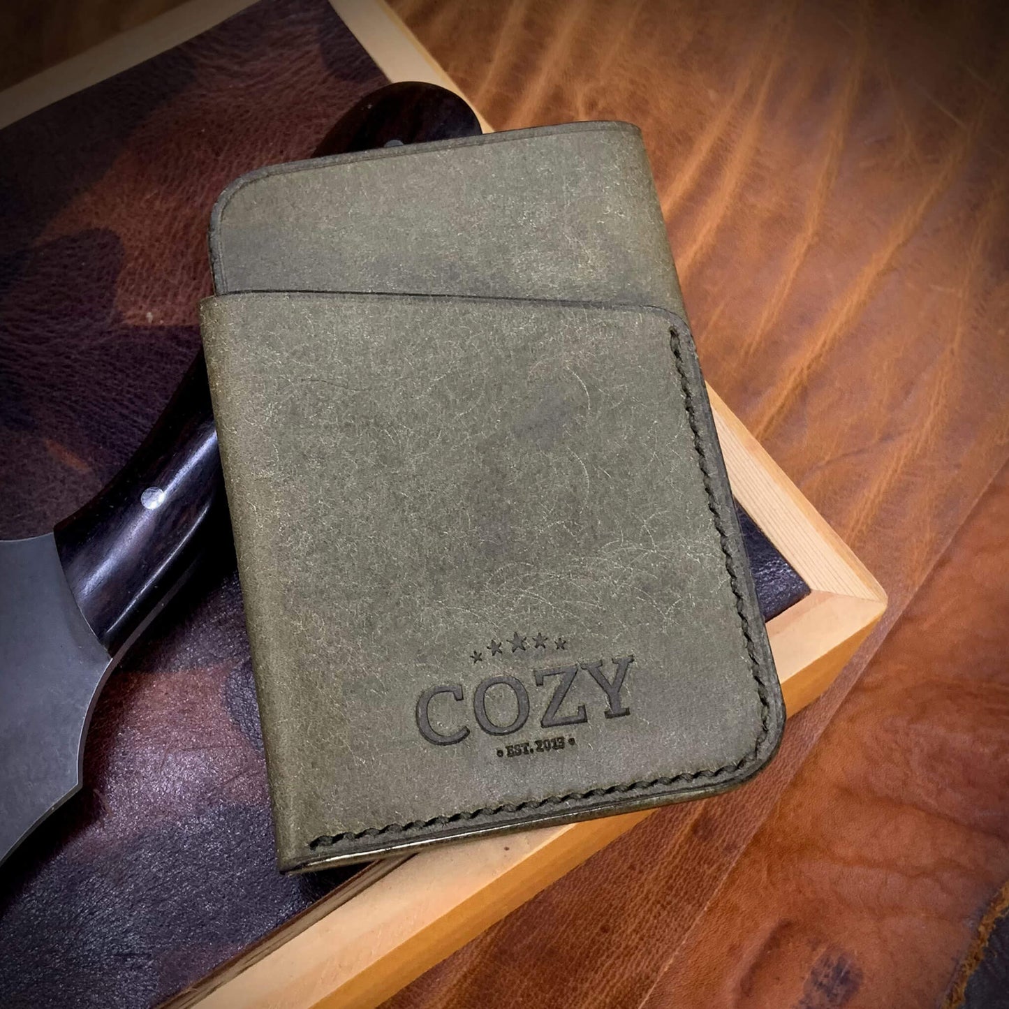 COZY Slim Sleeve Wallet in pueblo rustic olive full grain leather, showing COZY stamp and saddle stitching detail