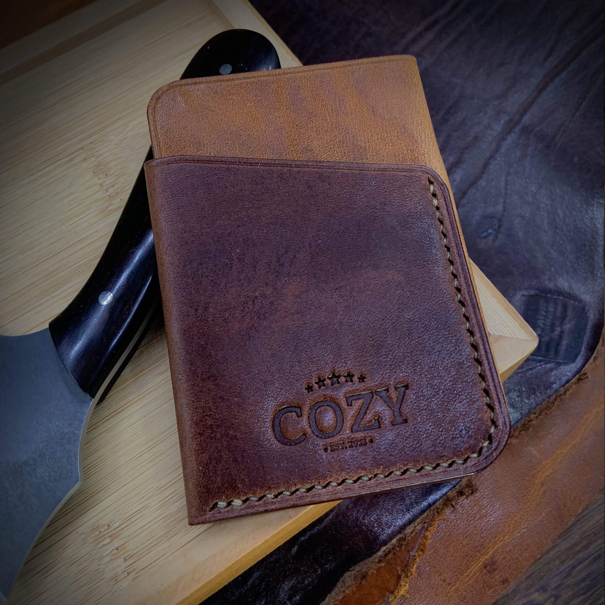 COZY Slim Sleeve Wallet in two-tone tan and dark brown full grain leather, showing COZY stamp and saddle stitching detail