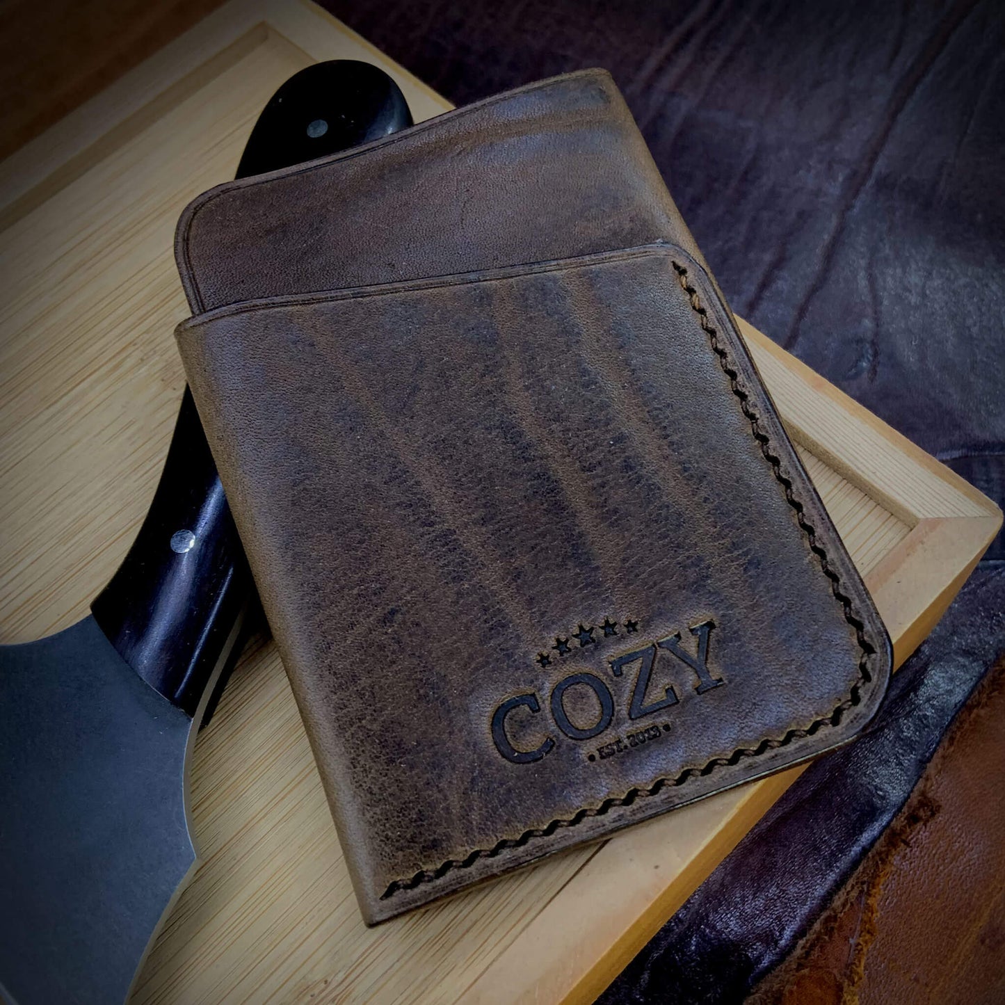 COZY Slim Sleeve Wallet in distressed brown full grain leather, showing natural grain texture, COZY stamp and hand saddle stitching
