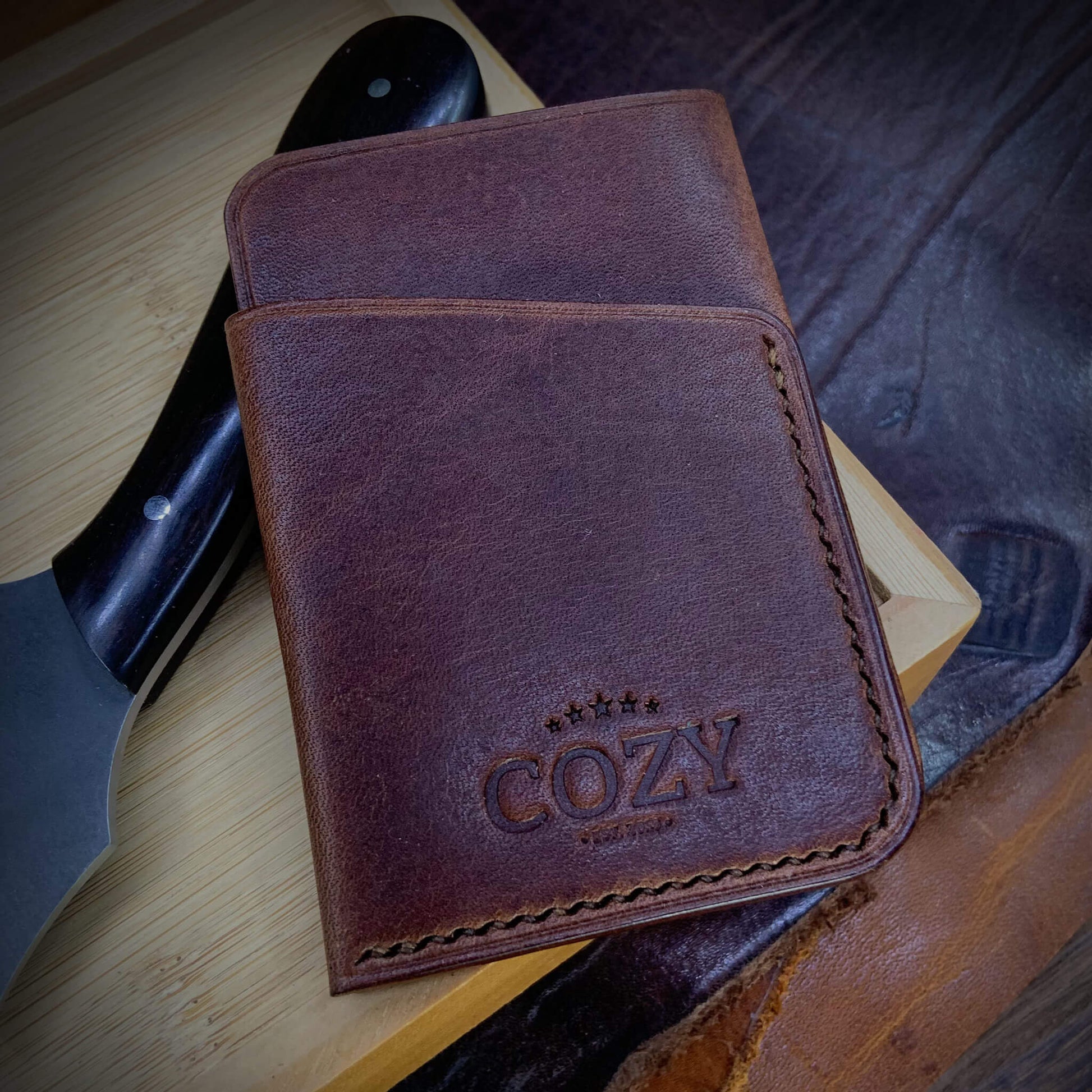 COZY Slim Sleeve Wallet in dark brown full grain leather, showing natural grain texture, COZY stamp and hand saddle stitching
