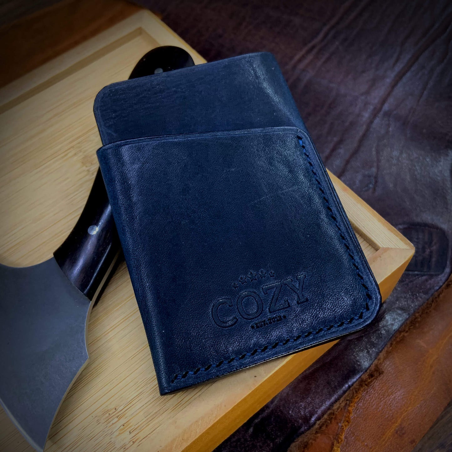 COZY Slim Sleeve Wallet in deep navy full grain leather, showing COZY stamp, saddle stitching and back card sleeve