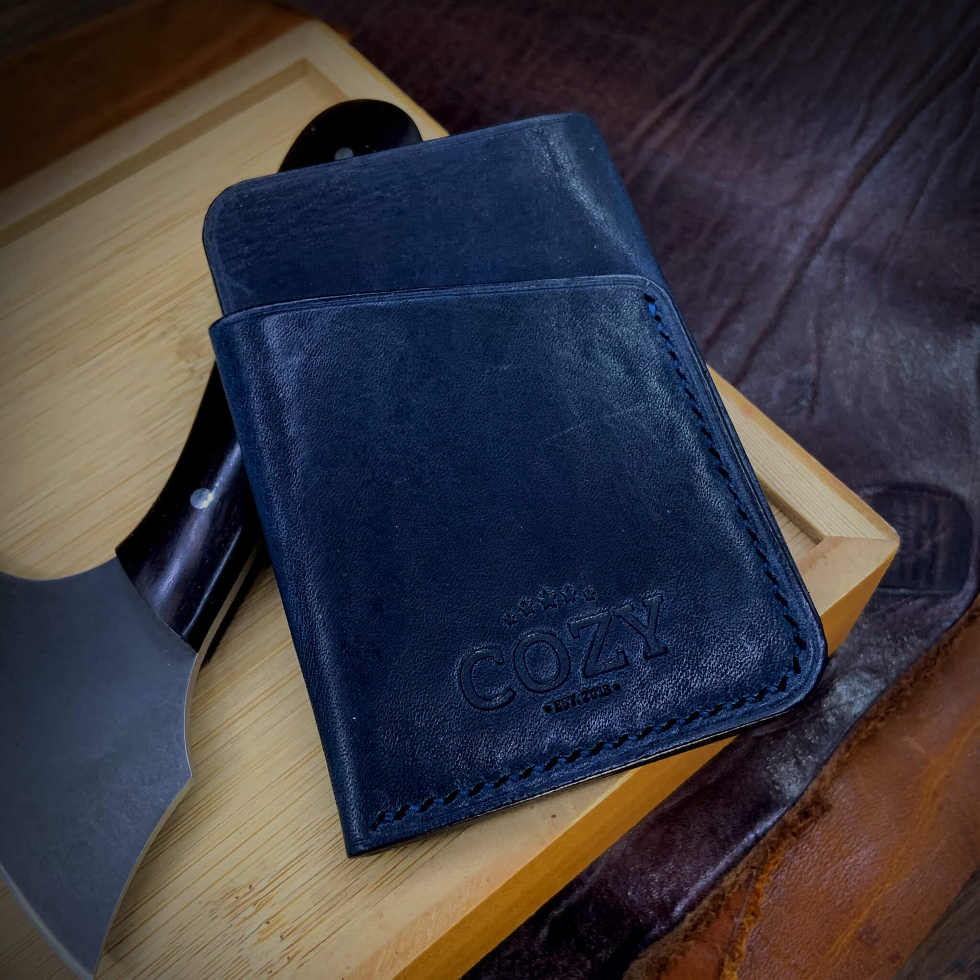 COZY Slim Sleeve Wallet in deep navy full grain leather, showing COZY stamp, saddle stitching and back card sleeve