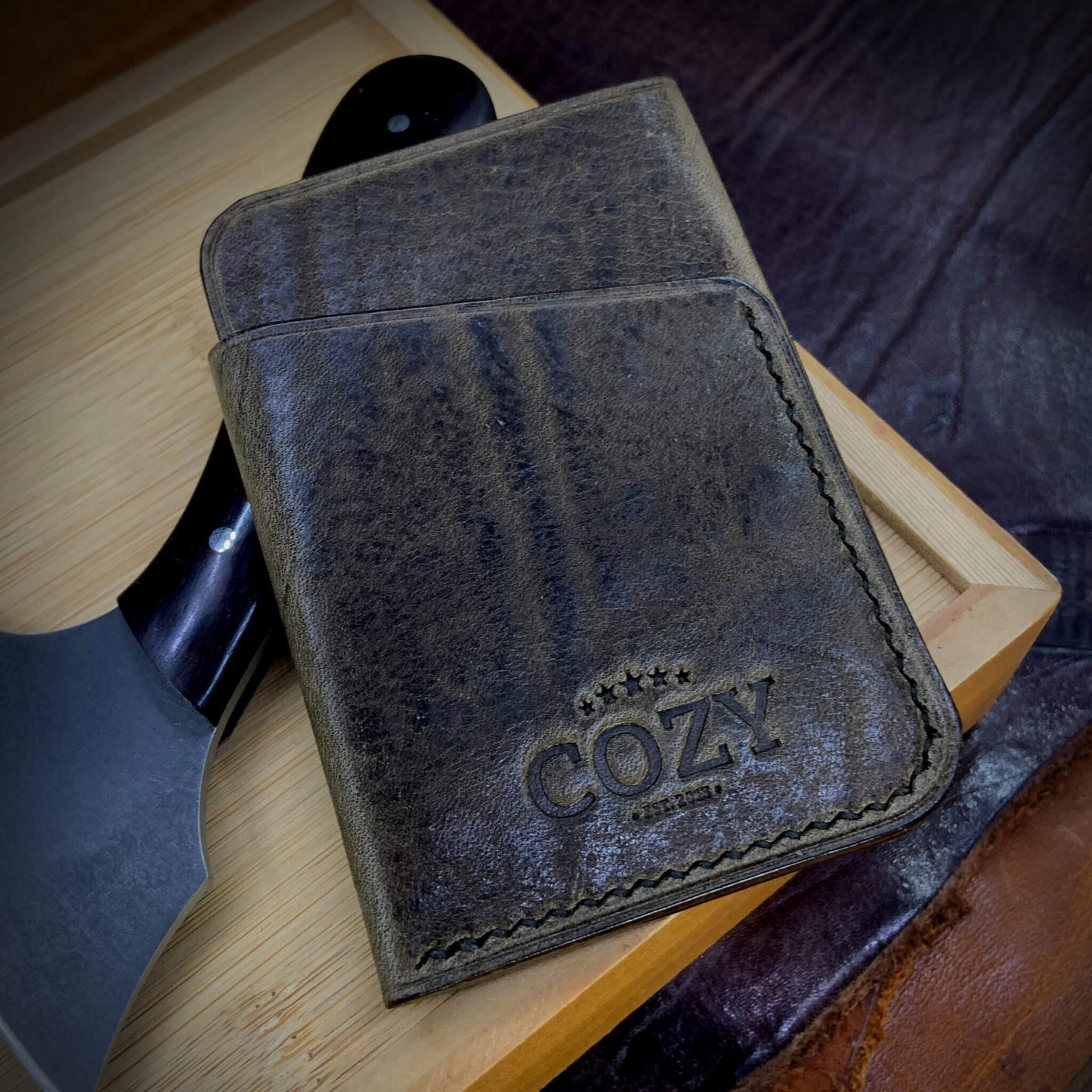 COZY Slim Sleeve Wallet in distressed olive full grain leather, showing natural pull-up markings, COZY stamp and hand saddle stitching