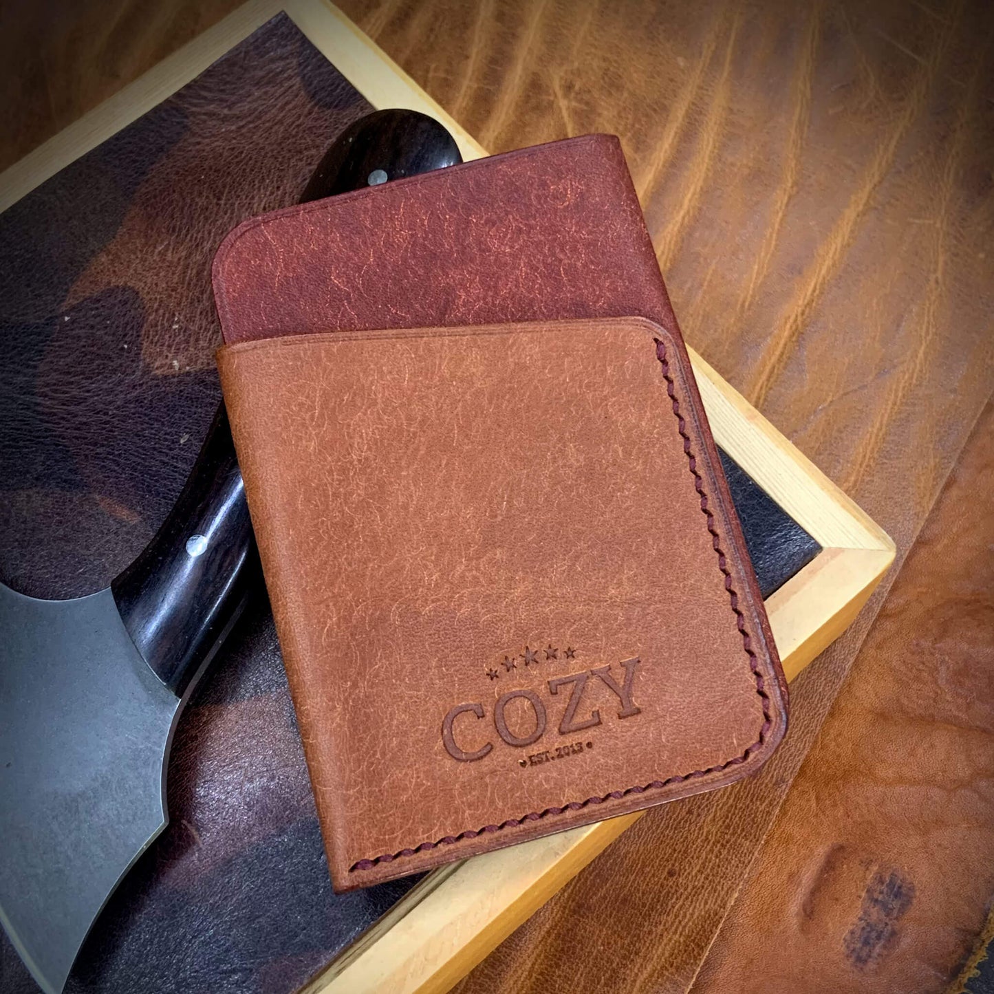 COZY Slim Sleeve Wallet in two-tone pueblo cocinella and russet full grain leather, showing COZY stamp and saddle stitching detail
