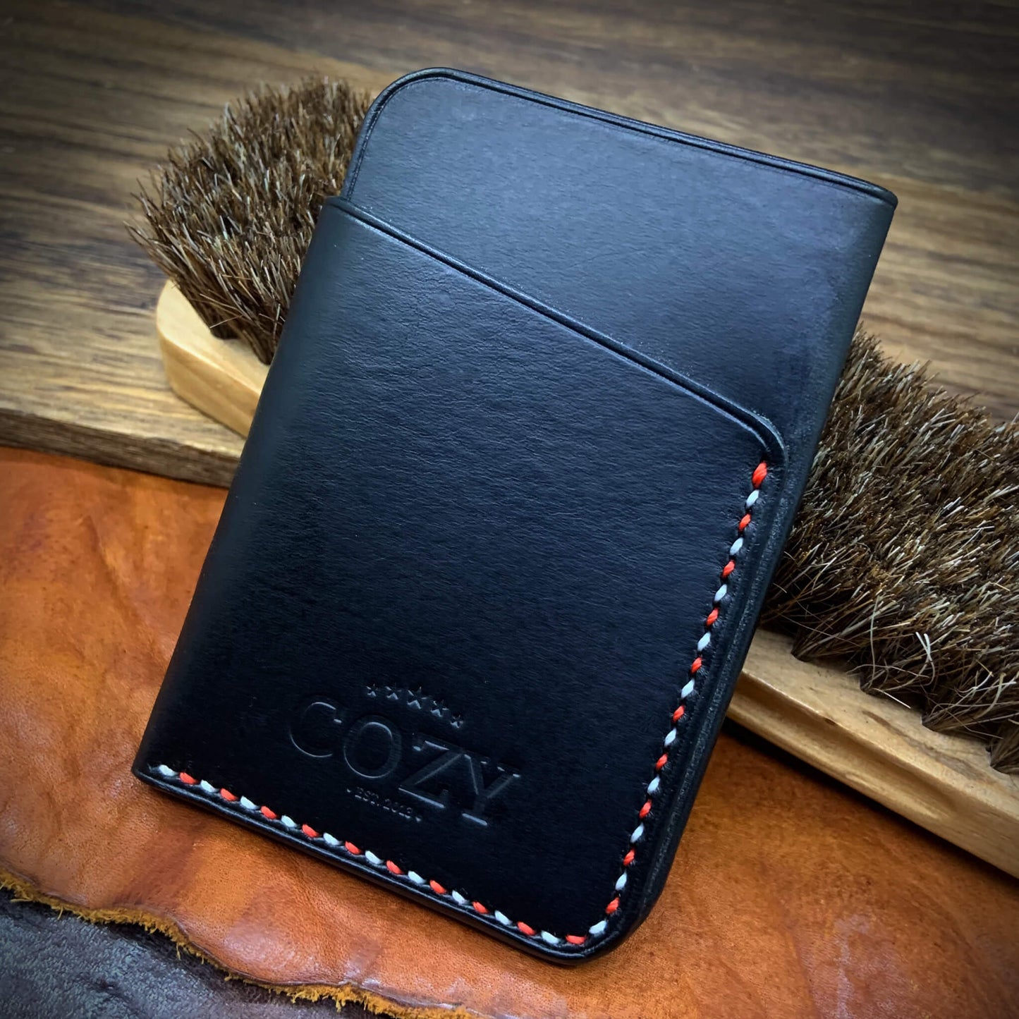 COZY Slim Sleeve Wallet SG Edition — back view showing pure black full grain leather, COZY stamp and alternating red and white hand saddle stitching
