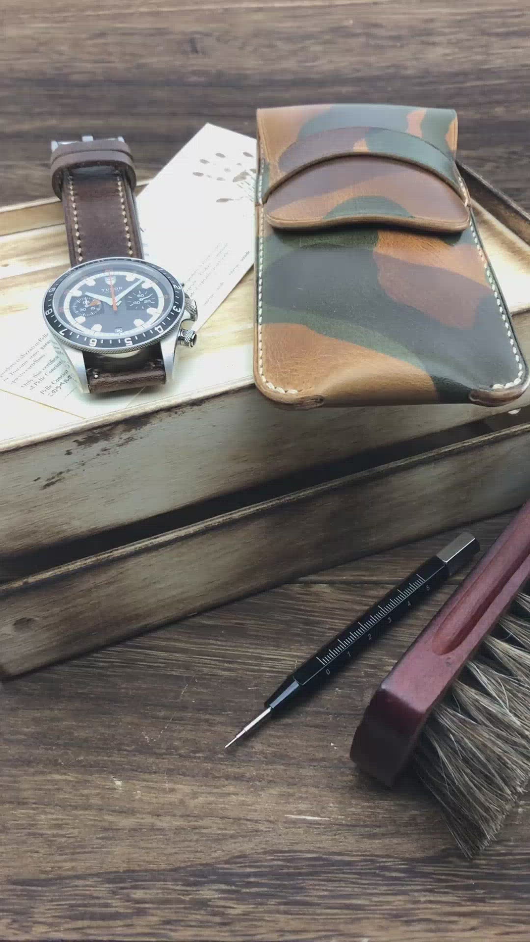 Video demonstrating a handcrafted camouflage leather watch pouch by Cozy Handmade, showing the secure strap closure and its compact size for safe travel.