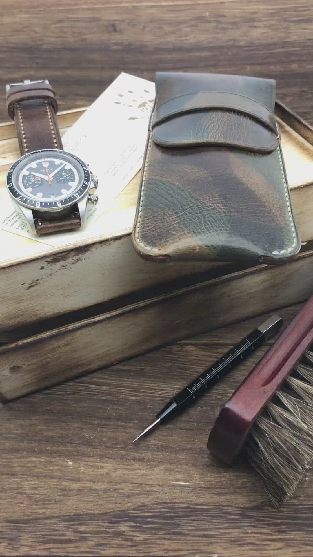 Video demonstration showing a luxury watch sliding smoothly into a lined, tan leather travel watch pouch by Cozy Handmade.