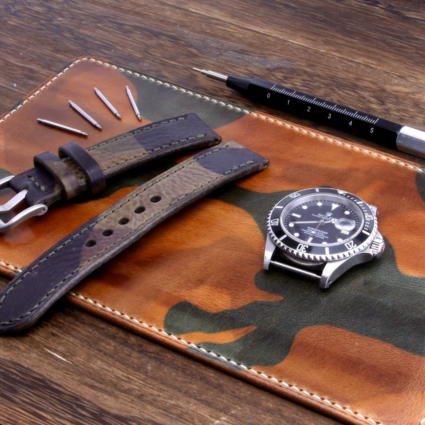 Handcrafted Leather Watch Valet | Military 101 (green and brown camouflage) Italian vegetable-tanned leather with luxury watches and strap resting on it — Cozy Handmade
