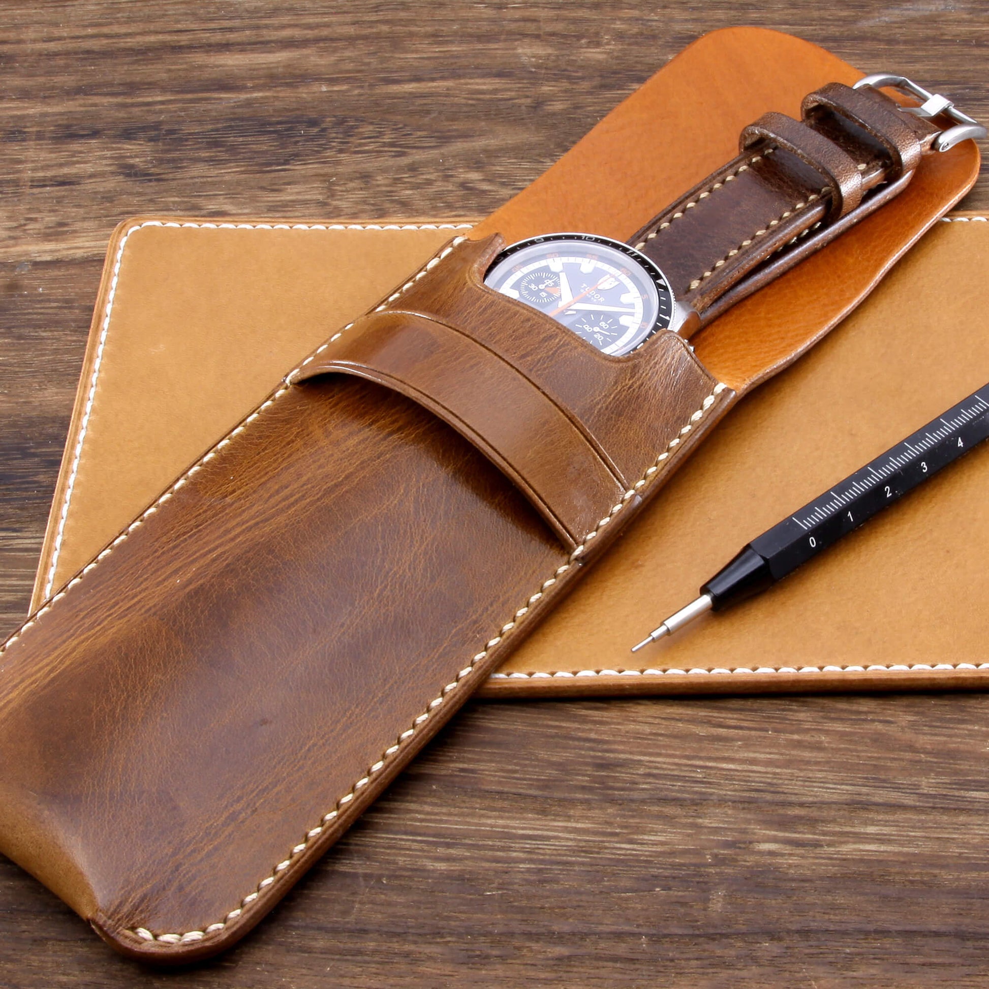 Premium Italian vegetable-tanned leather watch slip case in Military 102 featuring off-white contrast stitching, resting on a leather valet and wooden desk. Hand crafted by Cozy Handmade