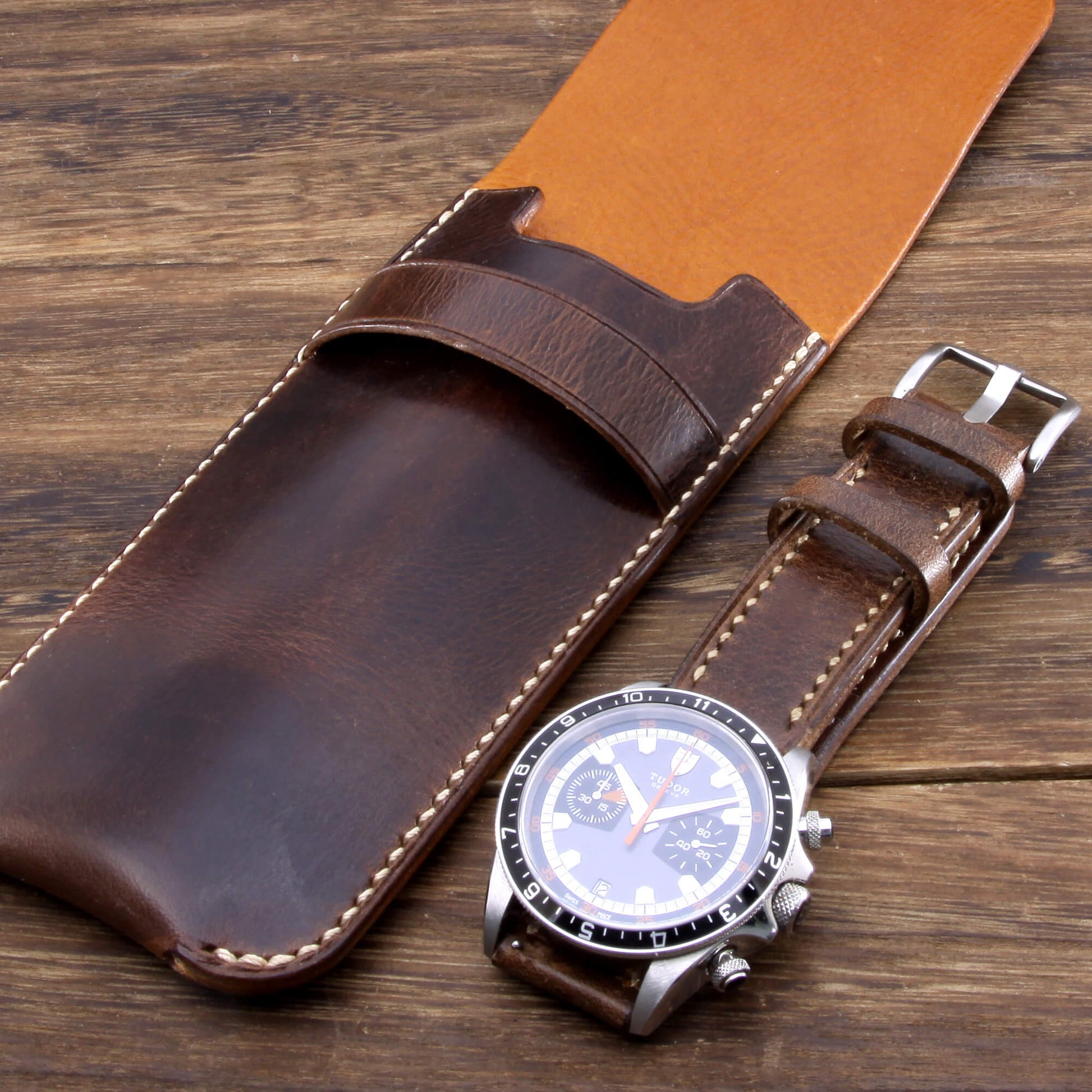 Lined leather watch pouch built for travel hand crafted by Cozy Handmade, displayed on a wooden desk next to a luxury watch.
